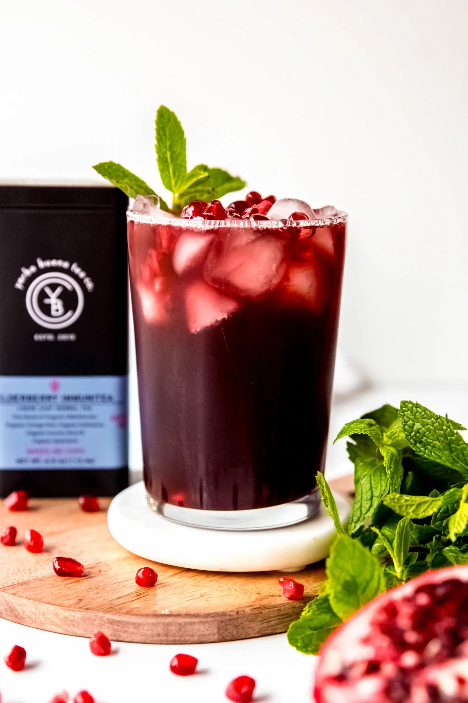 Ruby-red elderberry mocktail poured over ice in a clear glass, made with organic elderberry herbal tea by Yerba Buena Tea Co.