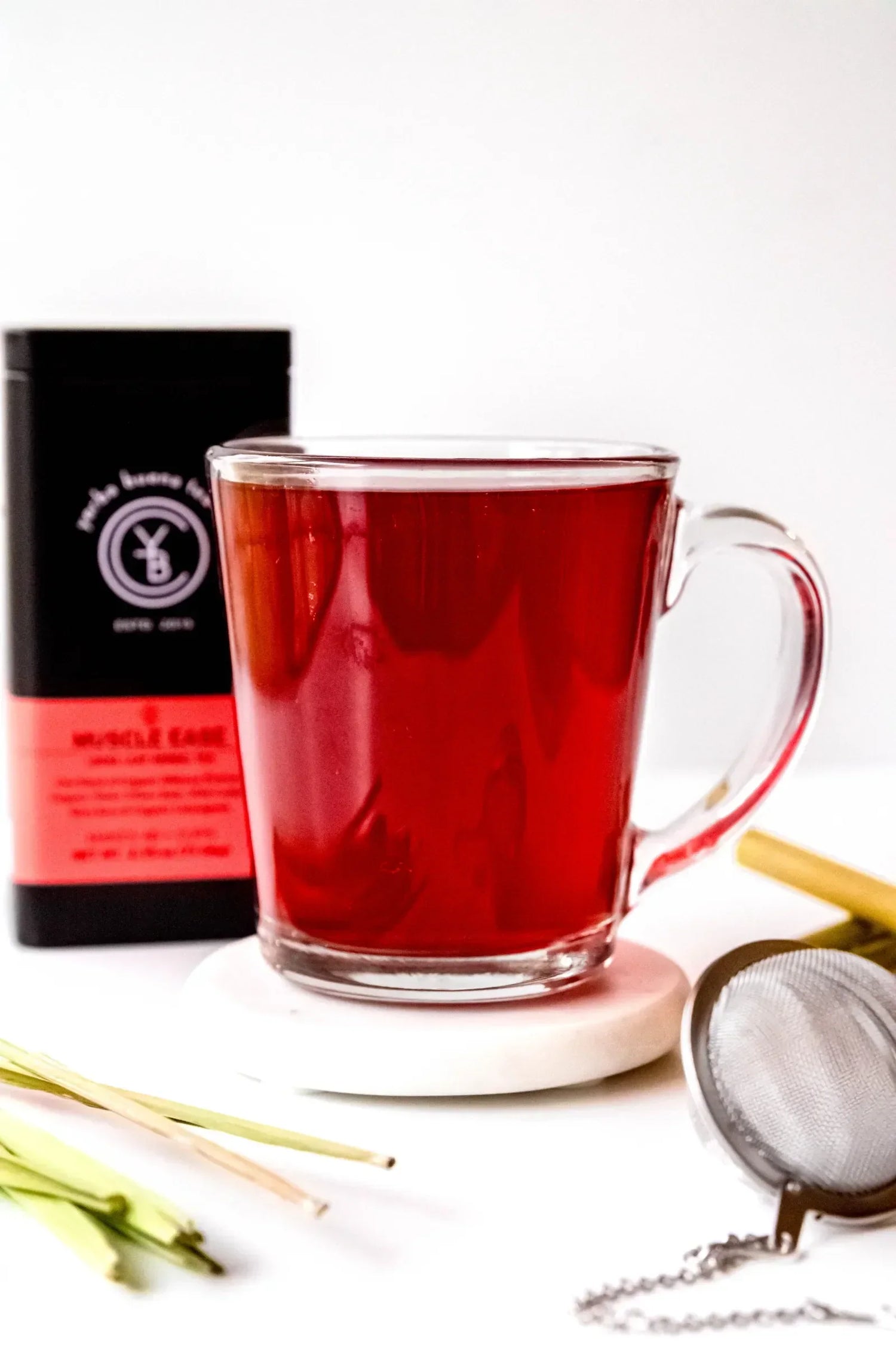 Brewed cup of organic Muscle Ease herbal tea with hibiscus and lemongrass, by Yerba Buena Tea Co.
