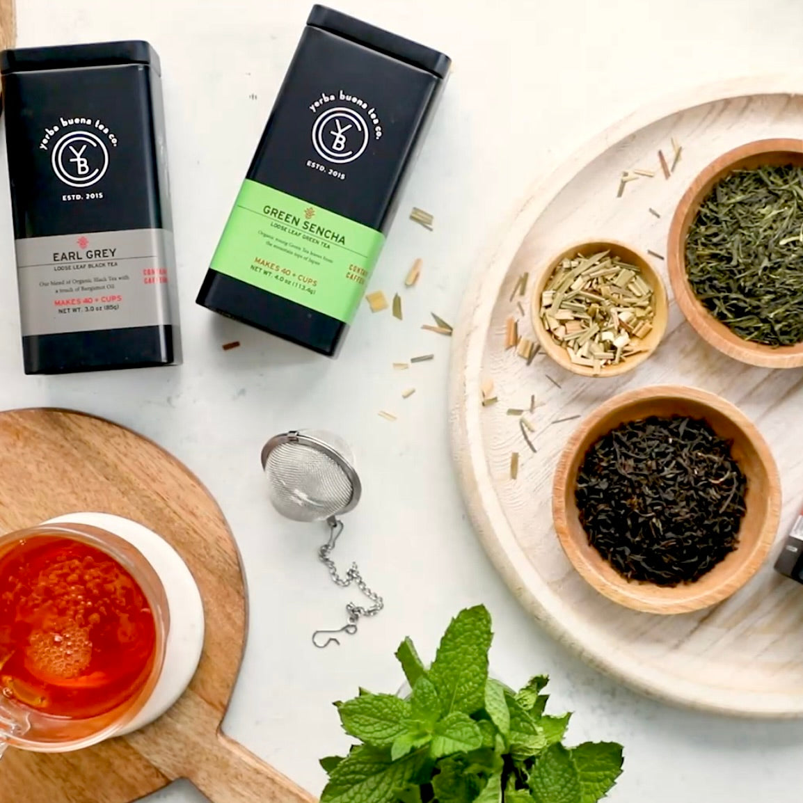 Gradient of organic tea leaves showing the difference between white, green, oolong, and black tea processing.