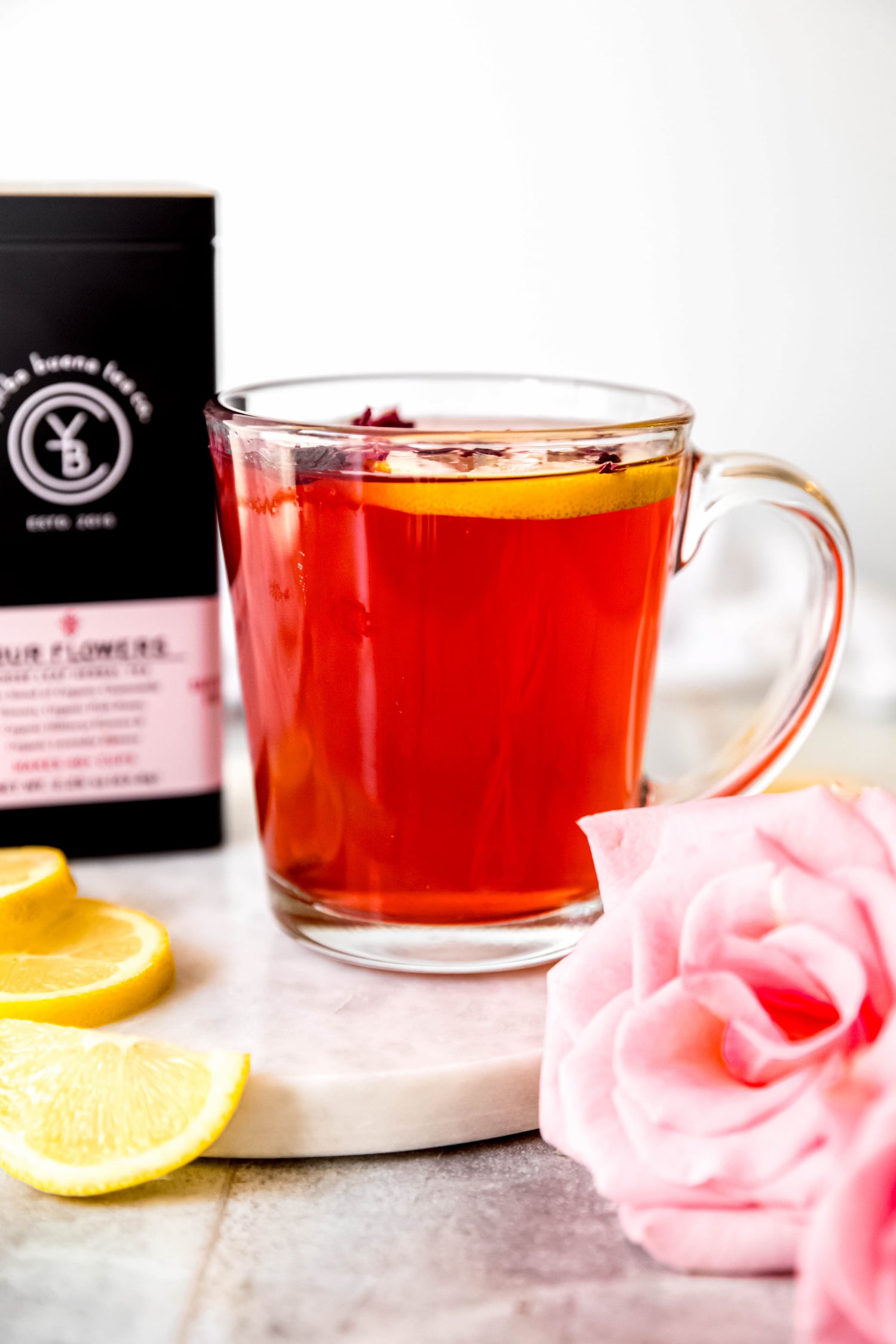 Ruby-red floral hot toddy with lemon and rose petals, brewed from organic Four Flowers herbal tea by Yerba Buena Tea Co.