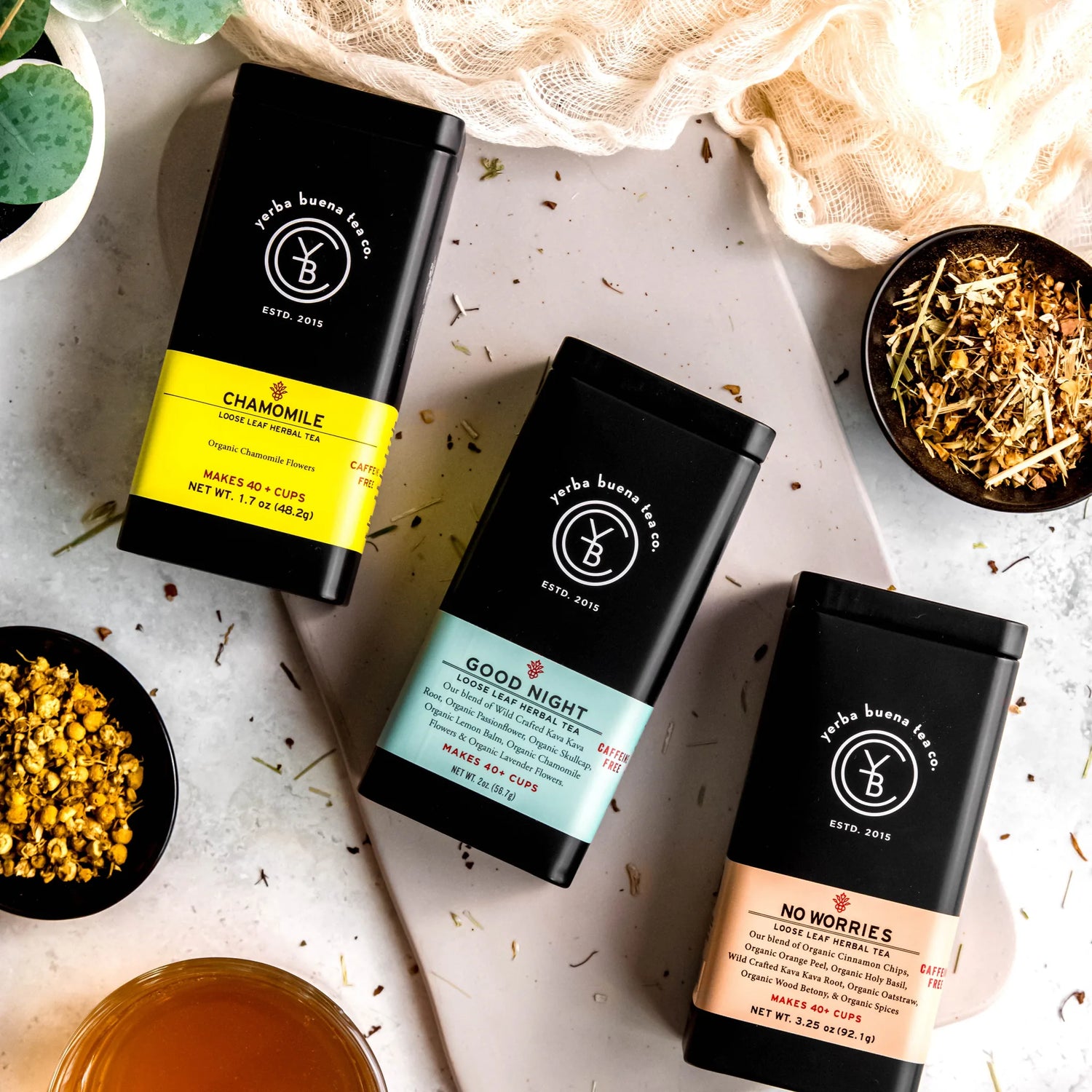 Bedtime Box gift set with three loose leaf herbal teas: Chamomile, Good Night, and No Worries in black pouches arranged on a neutral surface, by Yerba Buena Tea Company.