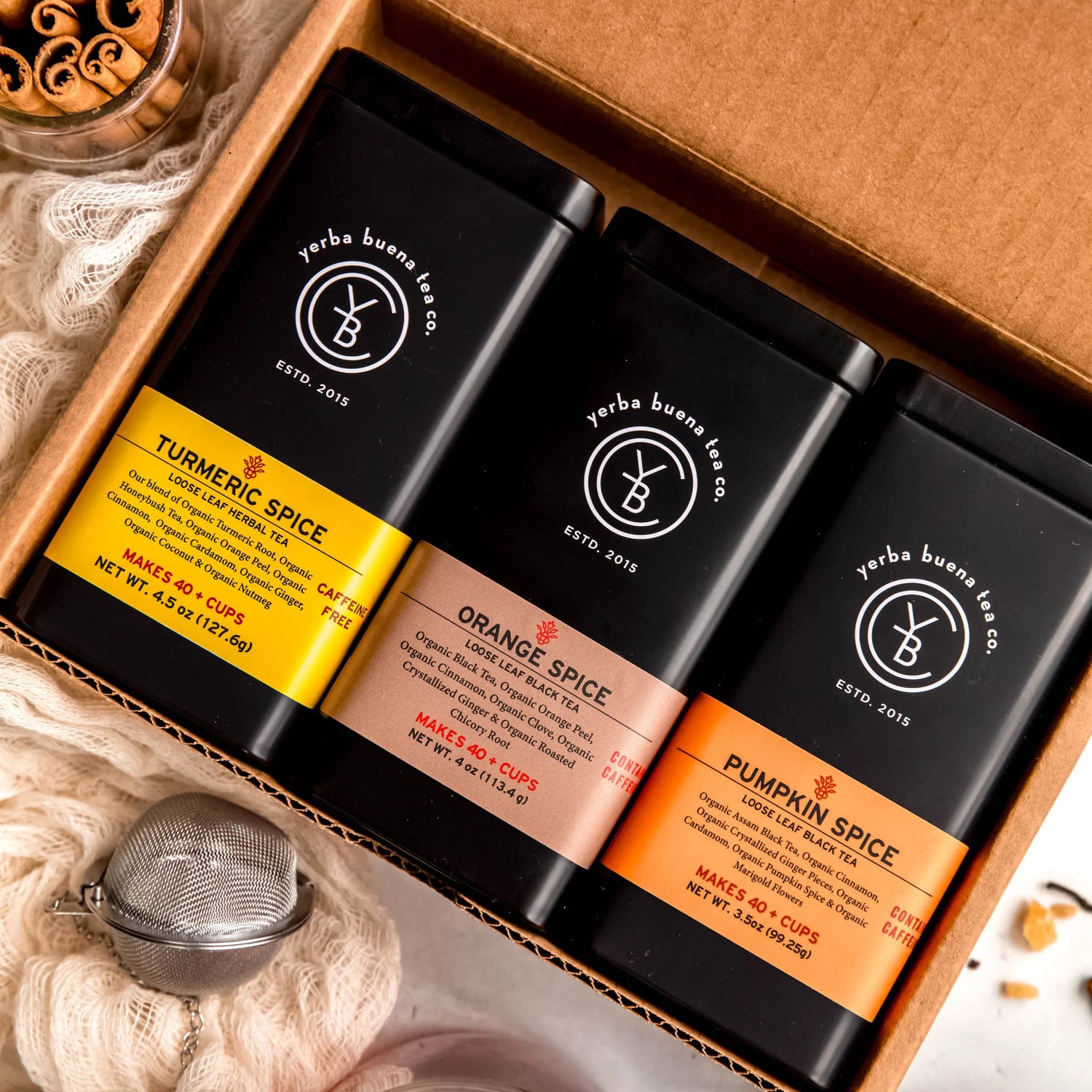 The Seasonal Spiced Gift Box Set containing three loose leaf teas: Turmeric Spice, Orange Spice, and Pumpkin Spice in branded pouches arranged in a kraft box, by Yerba Buena Tea Company.