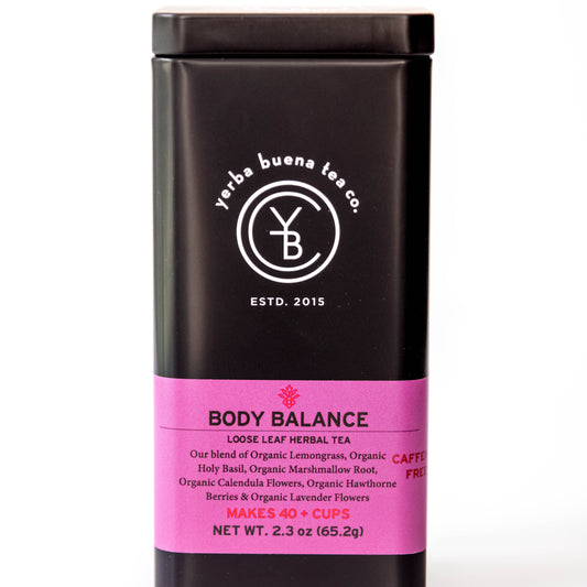 The Yerba Buena Tea Co. Body Balance tea tin, labeled with the blend’s name and ingredients, in a sleek black container with a pink label. The text on the tin emphasizes that the blend is organic, caffeine-free, and makes 40+ cups, perfect for those seeking balance and tranquility in a cup.