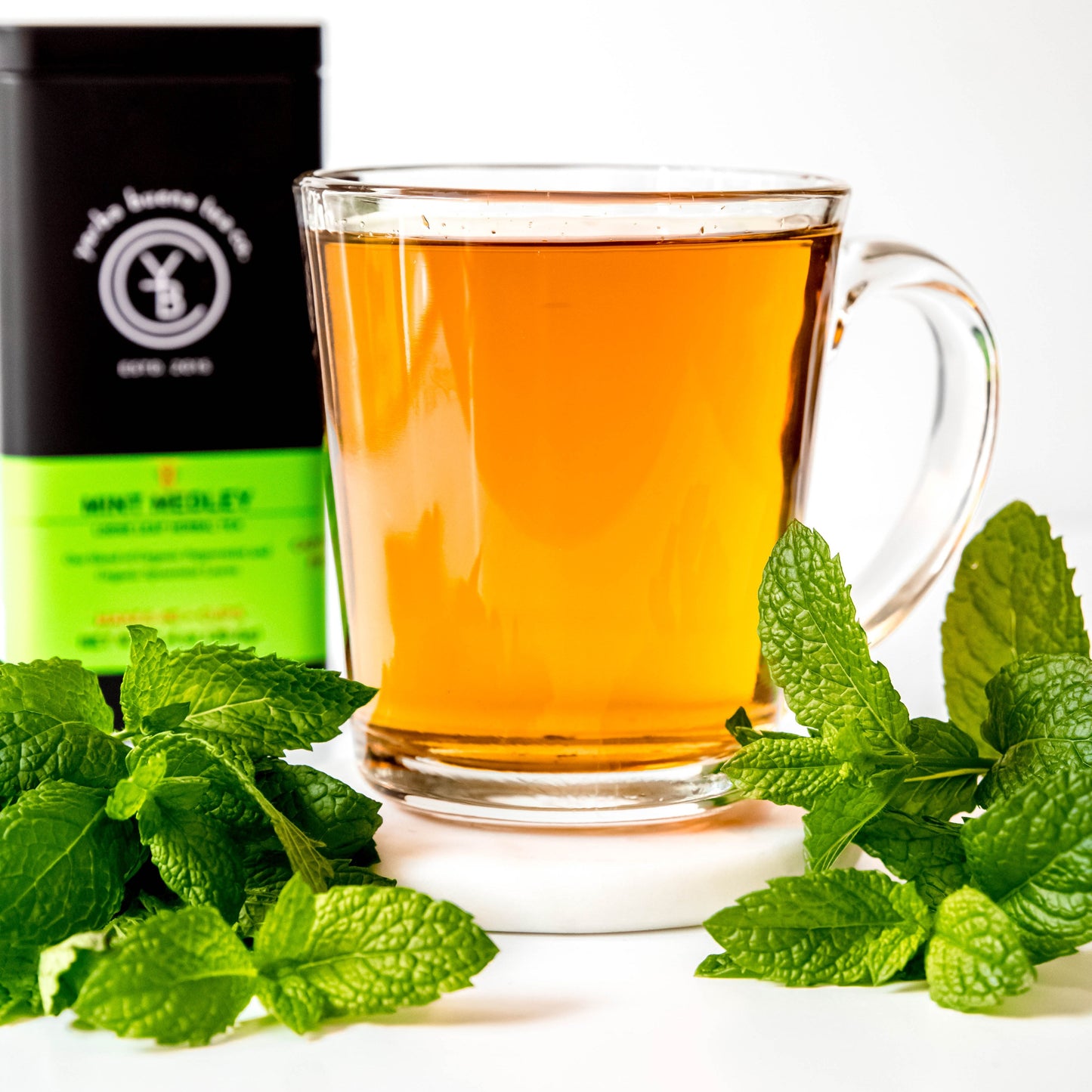 A cup of brewed Mint Medley tea with a light golden hue, exuding a refreshing minty aroma.