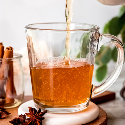 Brewed Chai tea pouring into a cup from Yerba Buena Tea Co. A vibrant black tea blend with organic Assam black tea, ginger, cardamom, cinnamon, nutmeg, and star anise.