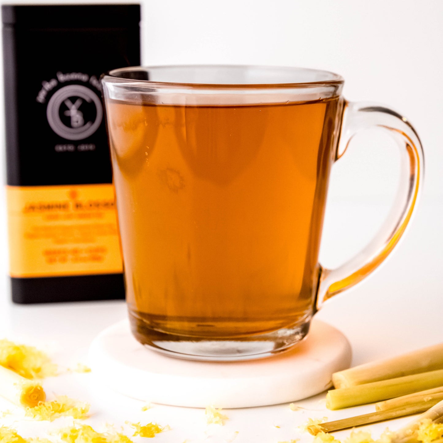 A cup of brewed Jasmine Blossom tea with a light golden hue, exuding a delicate floral and citrus aroma.