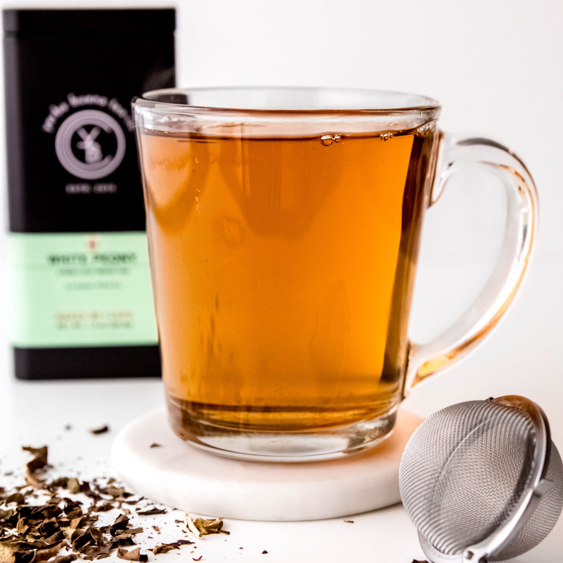 A cup of brewed White Peony tea with a pale golden hue, exuding a subtle floral aroma.