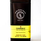 Chamomile loose leaf herbal tea in a black cylindrical canister with yellow label, by Yerba Buena Tea Company.