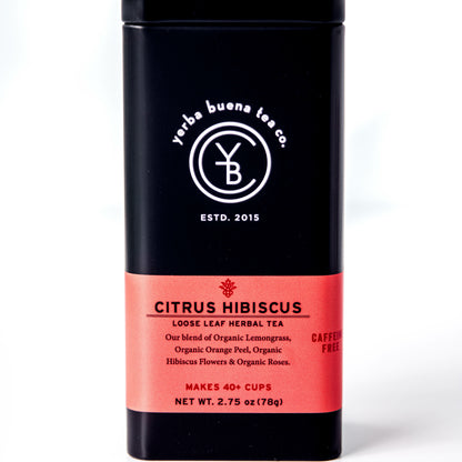 A black tin of Yerba Buena Tea Co.'s Citrus Hibiscus loose leaf herbal tea, labeled as caffeine-free and made with organic lemongrass, orange peel, hibiscus, and roses, on a white background.