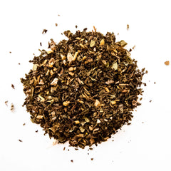 Loose leaf herbal detox tea blend with dried herbs and botanicals scattered on white background, by Yerba Buena Tea Company.