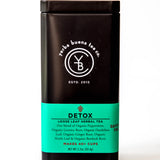 Detox loose leaf herbal tea in a black canister with turquoise label showing ingredients and brew count, by Yerba Buena Tea Company.