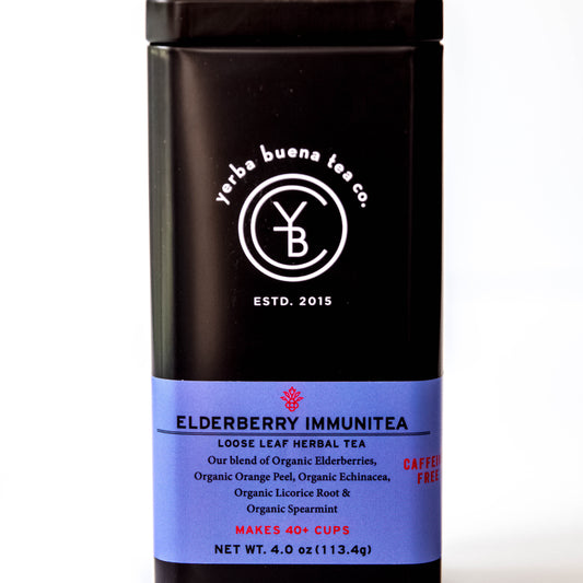 The Yerba Buena Tea Co. Elderberry Immunitea tea tin, labeled with the blend’s name and ingredients, in a sleek black container with a blue label. The text on the tin emphasizes that the blend is organic, caffeine-free, and makes 40+ cups, ideal for those seeking a health-boosting tea experience.