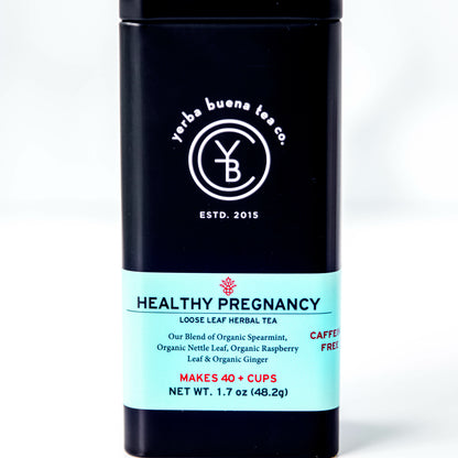 A black tin of Yerba Buena Tea Co.'s Healthy Pregnancy loose leaf herbal tea, labeled as caffeine-free and made with organic spearmint, nettle leaf, raspberry leaf, and ginger root, on a white background.