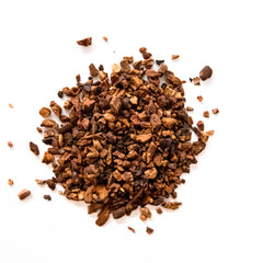 Loose cacao nibs and chicory root pieces scattered on white background, by Yerba Buena Tea Company.