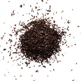 Loose leaf Irish Breakfast black tea with curled leaves scattered across white background, by Yerba Buena Tea Company.