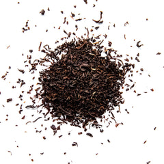 Loose leaf Irish Breakfast black tea with curled leaves scattered across white background, by Yerba Buena Tea Company.