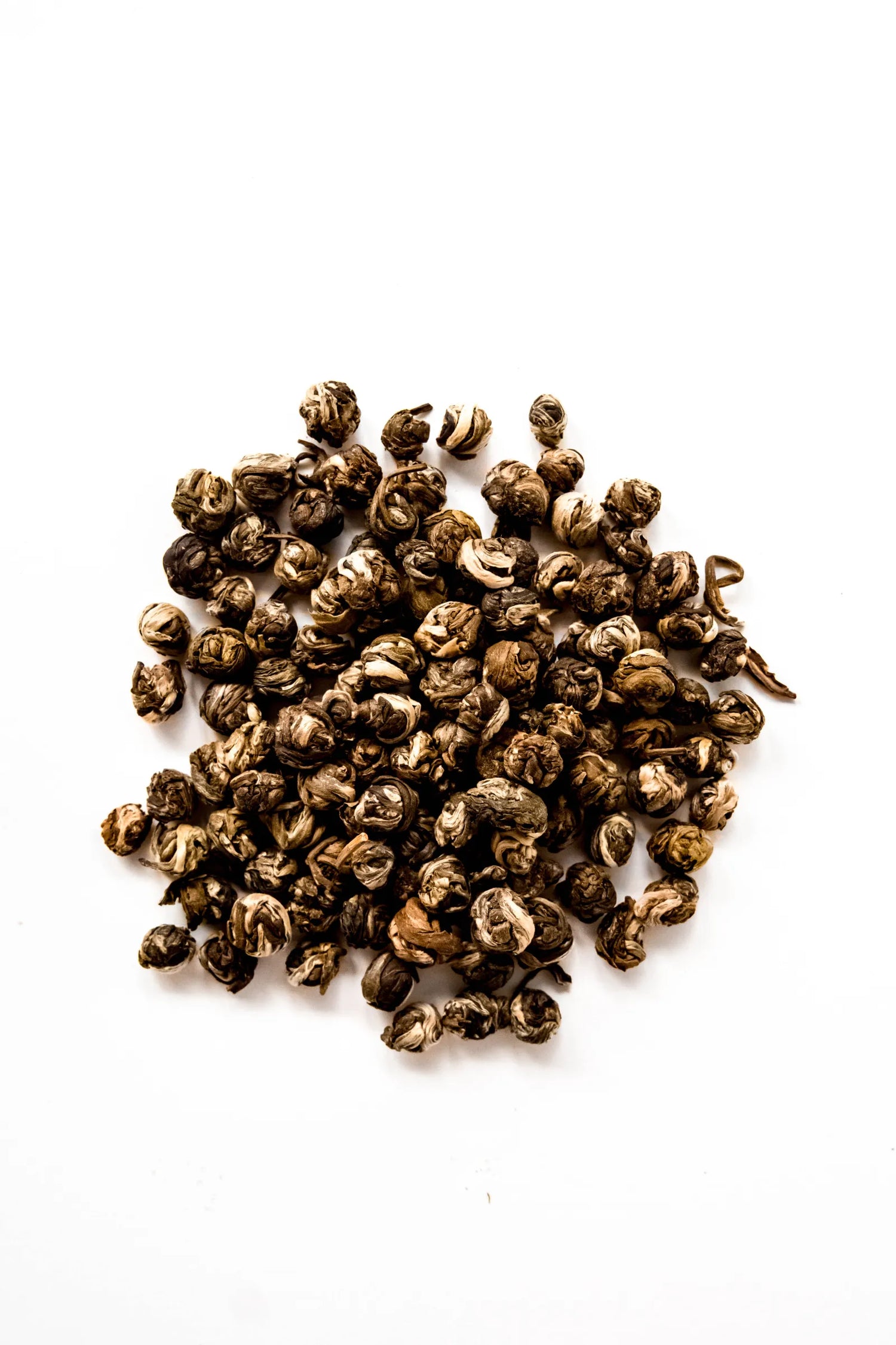 Hand-rolled Jasmine Pearls organic green tea displayed on a white background, featuring tightly rolled green tea leaves infused with fresh jasmine flowers. A traditional loose leaf green tea handcrafted in Oregon.