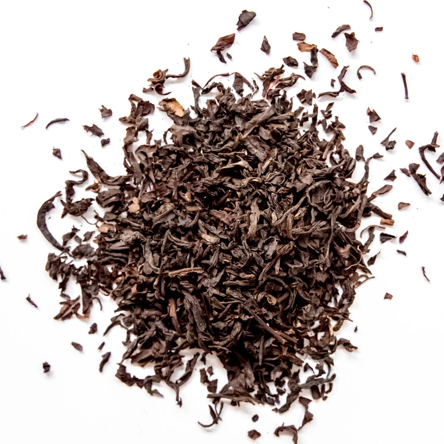 Lapsang Souchong loose leaf black tea scattered on white background, by Yerba Buena Tea Company.