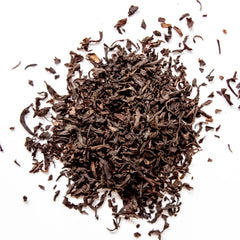 Lapsang Souchong loose leaf black tea scattered on white background, by Yerba Buena Tea Company.