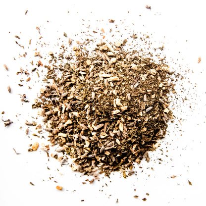 A close-up of the loose leaf blend of Lavender Ginger Mint tea, showing the finely chopped organic spearmint, ginger root, and lavender flowers against a white background.