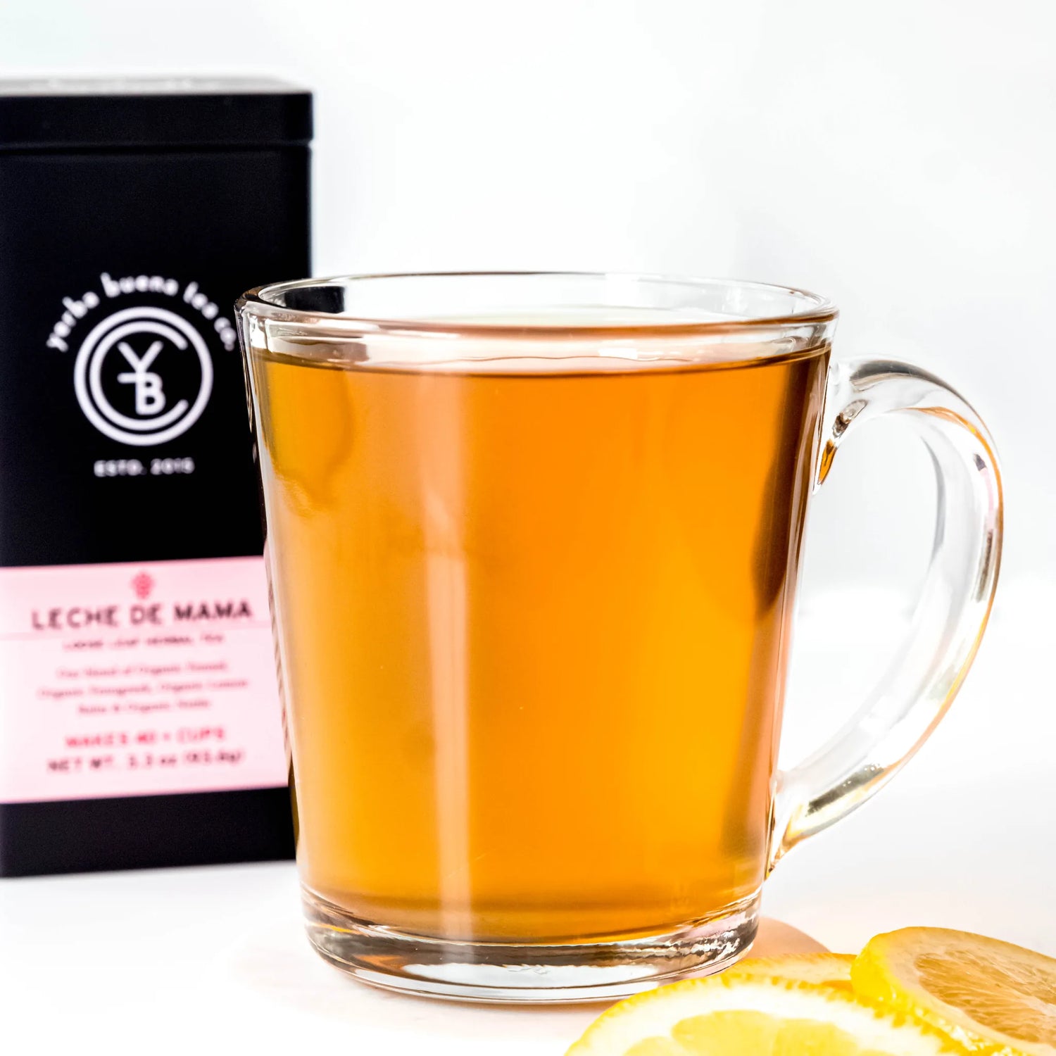 Brewed Leche de Mama tea in clear glass mug with packaging visible behind it, by Yerba Buena Tea Company.