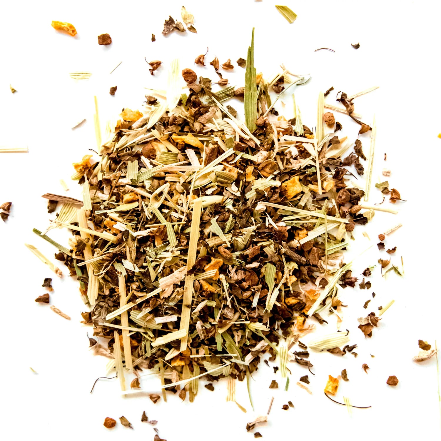 Loose leaf herbal tea blend with dried grasses, flowers, and botanical pieces scattered on white background, by Yerba Buena Tea Company.