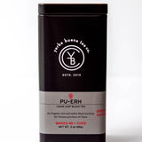 Pu-Erh loose leaf black tea in a black canister with gray label band, by Yerba Buena Tea Company.