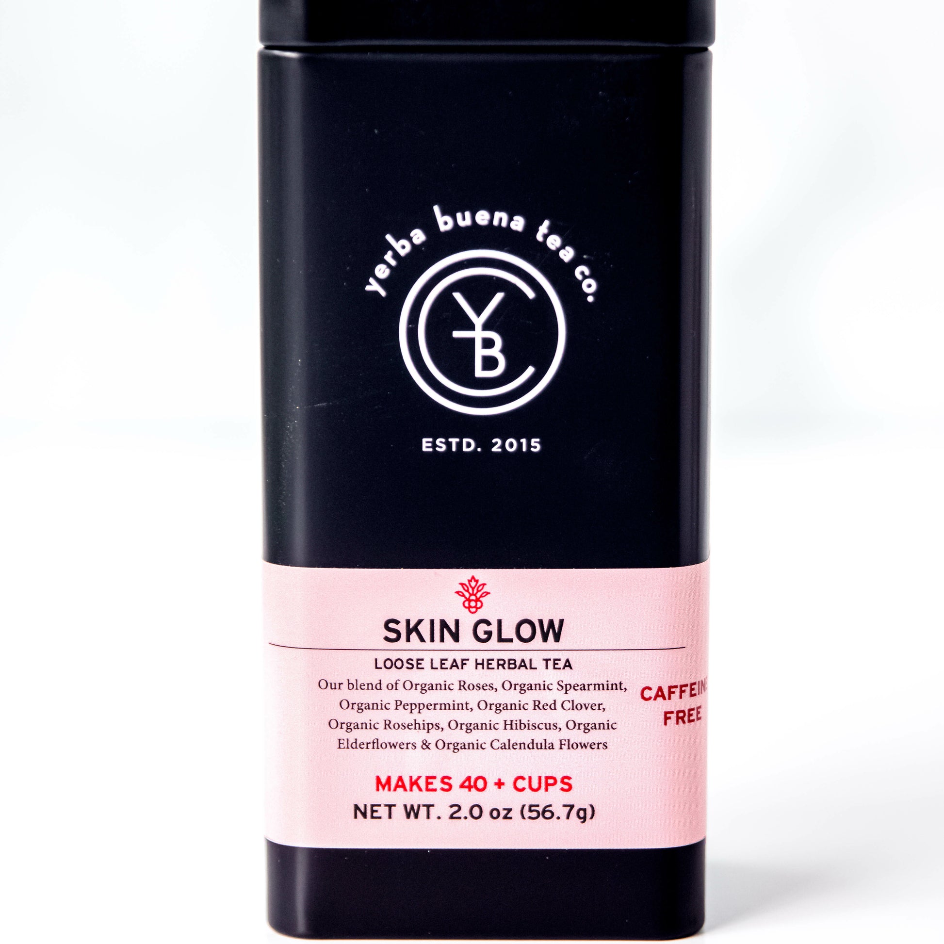 A black tin of Yerba Buena Tea Co.'s Skin Glow loose leaf herbal tea, labeled as caffeine-free and made with organic spearmint, peppermint, red clover, rosehips, hibiscus, roses, elderflowers, and calendula flowers, on a white background.