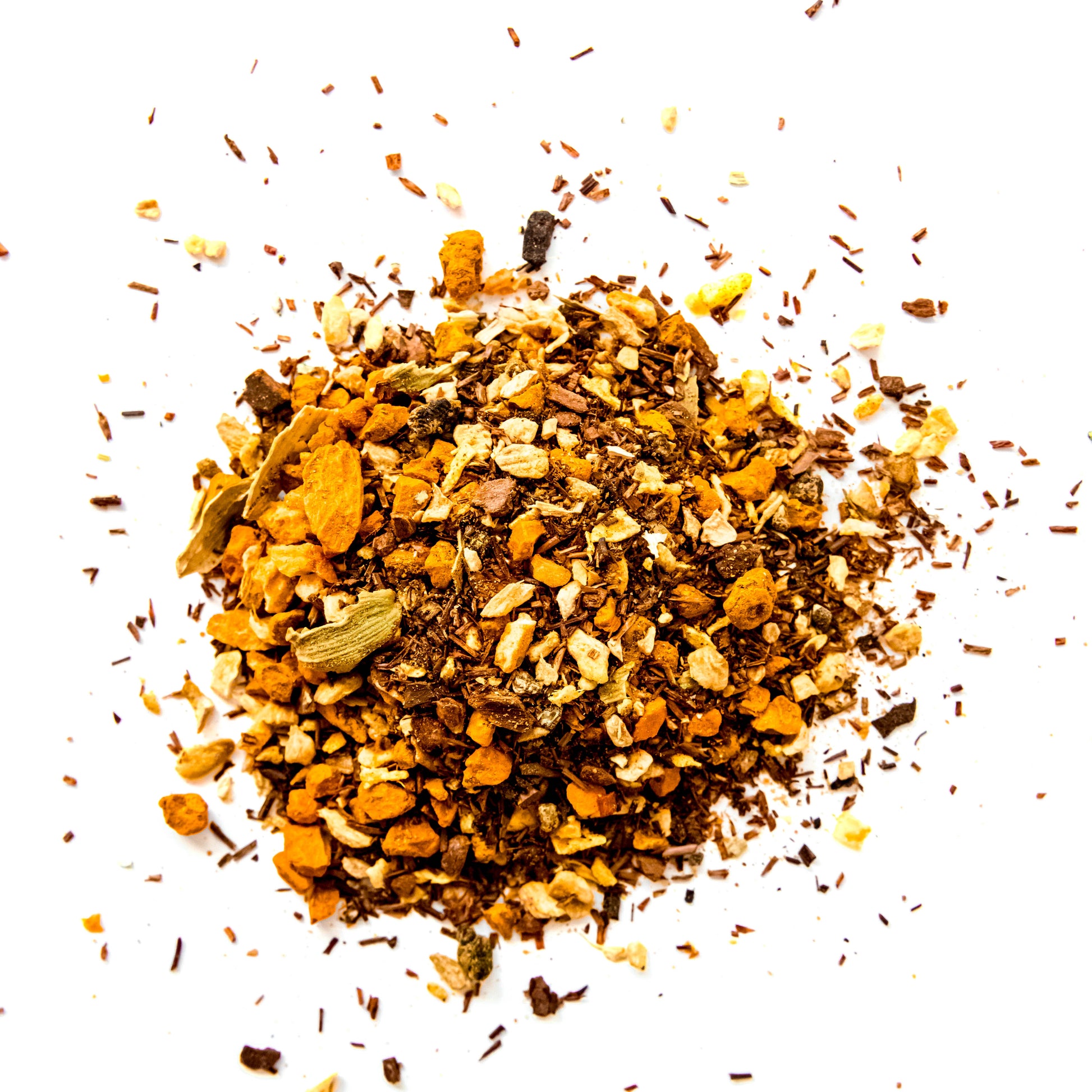 A close-up of loose-leaf Turmeric Spice tea blend, featuring vibrant orange turmeric root, pieces of honey bush, orange peel, cinnamon, cardamom, ginger, coconut, and nutmeg. The blend is displayed against a clean white background, highlighting the rich colors and textures of the ingredients.